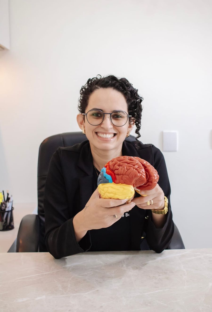 Aline Vicente segurando um modelo anatômico do cérebro
